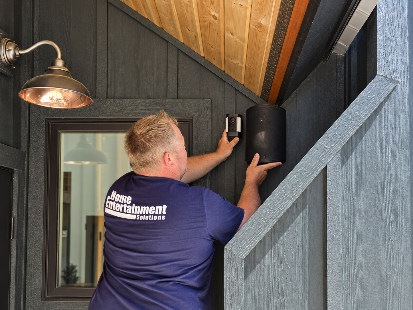 HES installer carefully fitting a porch speaker